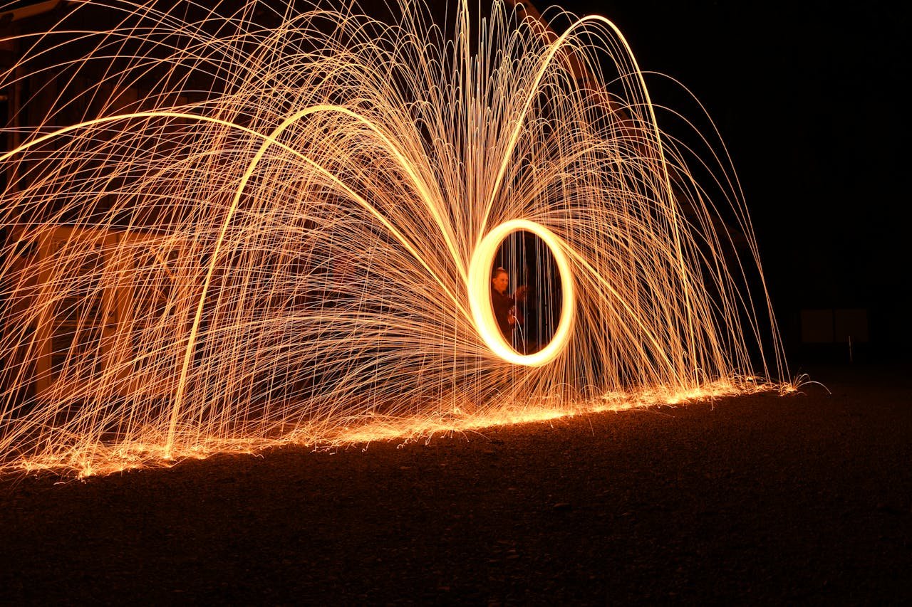 Woman Standing Behind an Illuminated Spinning Fireworks